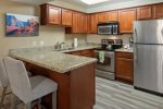 The newly-updated kitchen boasts modern appliances and granite counters